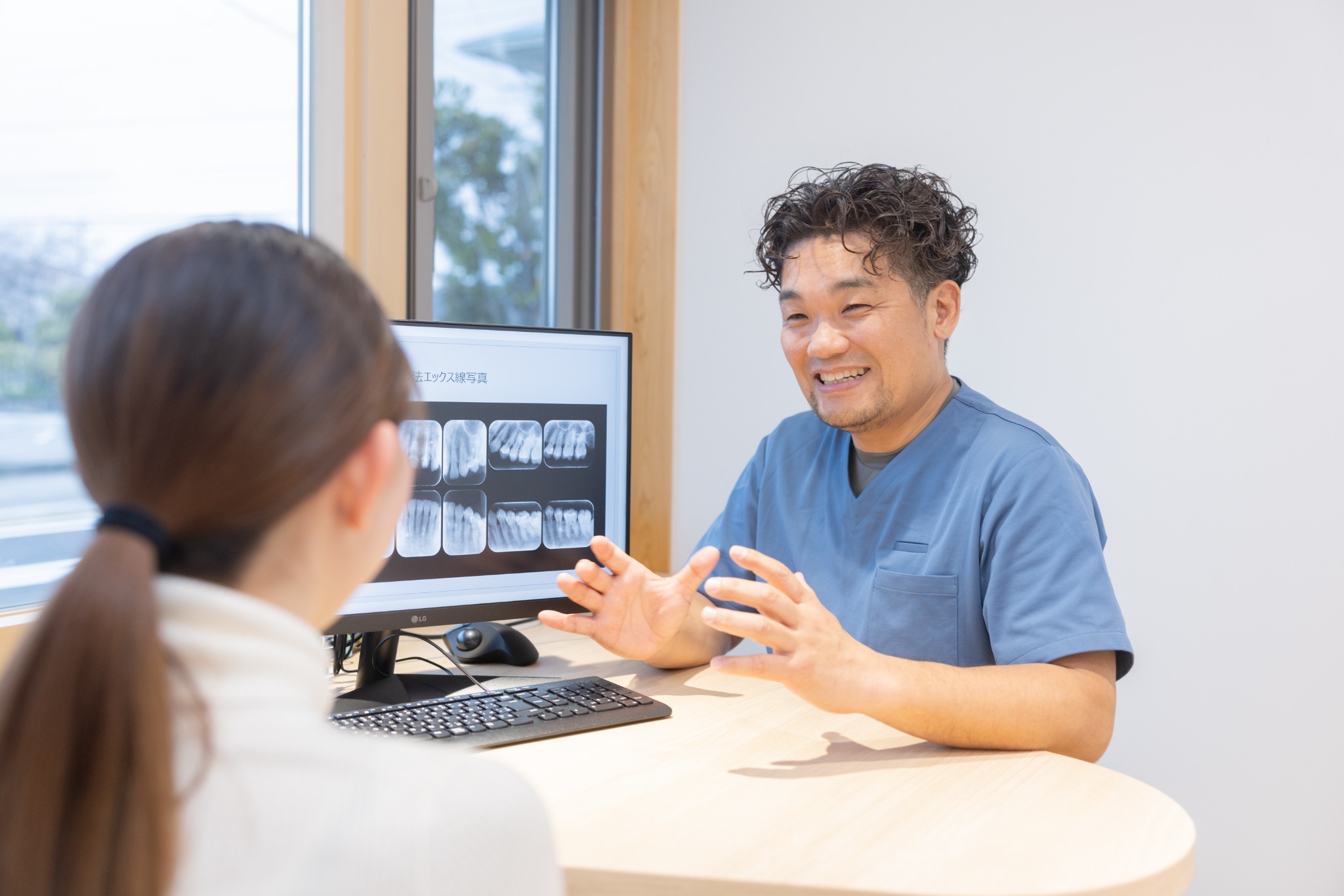 患者さんと向き合いながら説明する歯科医師